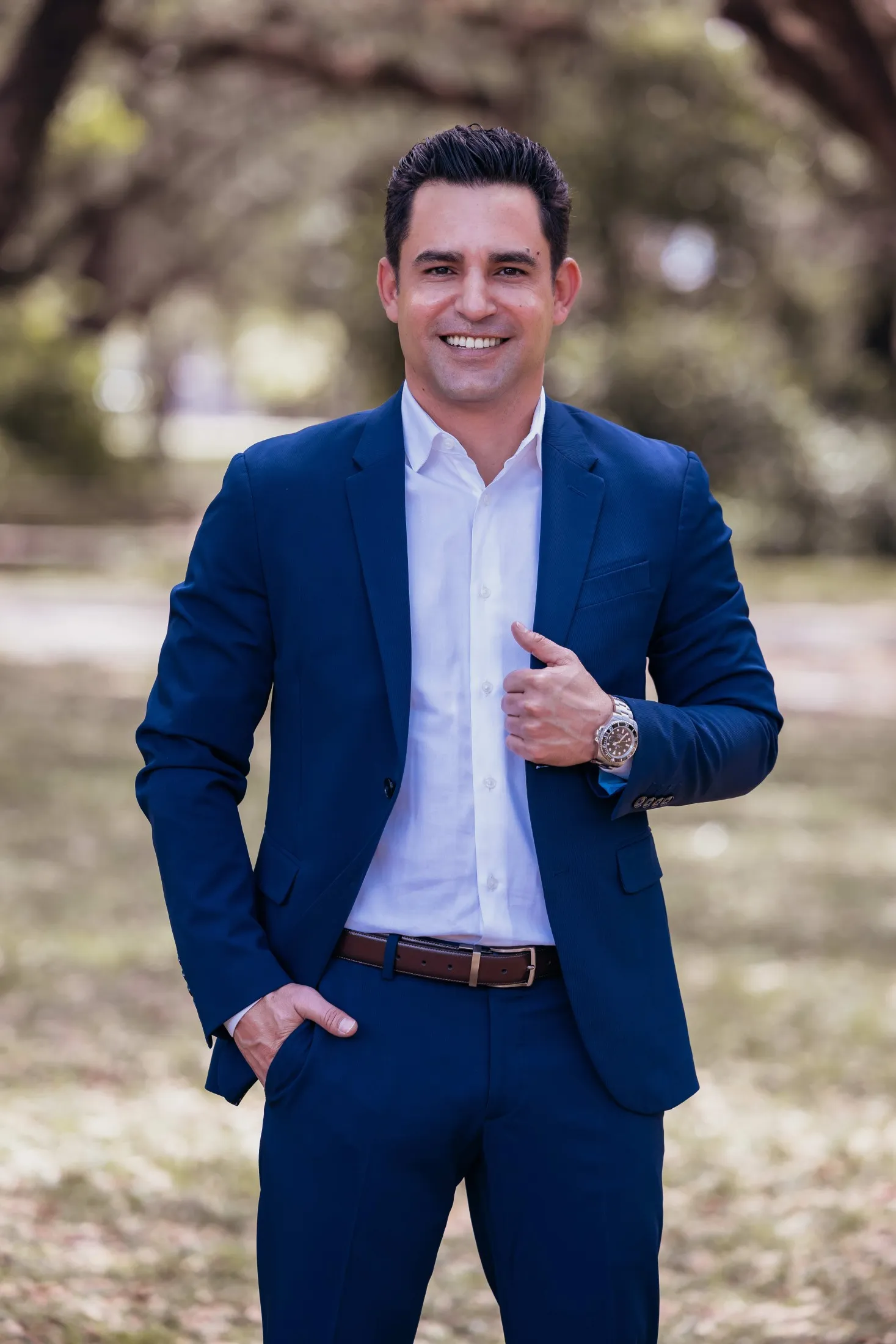 Dr. Manuel Zerquis Molina in a suit with a scenic backdrop 